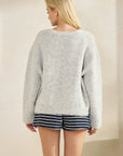 Back view of model wearing the BTTRMMT Gray Millie Cardigan, showing the soft oversized knit and relaxed drape over striped shorts.