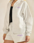 Close-up of BTTRMMT chill zip hoodie and shorts set with lilac logo, paired with a black tank for a cozy everyday look
