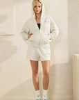 Model wearing BTTRMMT Chill Zip Hoodie and shorts set over a black tank, showcasing soft gray cozy casual loungewear.”