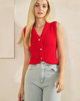 Model wearing BTTRMMT Rhea Knit Vest, vibrant red textured button-up vest with V-neckline, paired with light wash jeans.