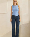 Front view of model wearing the BTTRMMT Blue Serenity Top with ribbed texture, side buttons, and asymmetrical hem paired with denim.