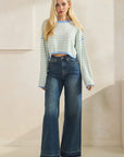 Model wearing BTTRMMT Blue Rumi Pop Stripe Knit, pastel blue and yellow cropped sweater with wide sleeves and dark jeans.