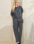 Model wearing BTTRMMT Ellie Striped Pants in navy and white with a relaxed wide-leg fit, paired with the matching striped top.