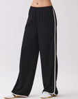 Close-up of the Nova Contrast Trim Pants in black featuring white side piping, elastic waistband, and relaxed fit.