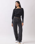 Side view of BTTRMMT Black Tessa Boatneck Sweater, relaxed off-shoulder knit with ribbed waist.