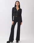 Model wearing BTTRMMT Calista Fit Flare Pants in black with a smooth waistband and flared legs, styled with a fitted black zip-up top.