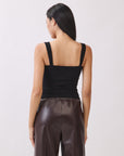 Back view of model wearing BTTRMMT The Brielle Top, a black ruched tank with wide straps, paired with brown faux leather pants.