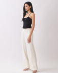 Model wearing BTTRMMT Ivory Sophia Pants with a high waist, pleated front, and wide-leg silhouette for an elegant, tailored look.