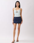 Model wearing BTTRMMT mint cutout tank top with scoop neckline, paired with dark denim mini skirt and heels.