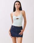 Model wearing BTTRMMT mint cutout tank top with scoop neckline, paired with dark denim mini skirt.