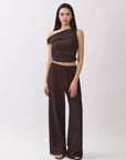 Model wearing the BTTRMMT Daniela Off-Duty Set in brown, featuring a one-shoulder ruched top and matching wide-leg pants for an elevated casual look.