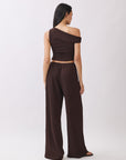 Back view of model wearing the BTTRMMT Daniela Off-Duty Set in brown featuring a fitted ruched back and matching wide-leg pants.