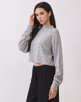 Side view of model wearing the BTTRMMT Elina High Neck Sweater in gray, a soft cropped knit with long sleeves.
