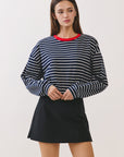 BTTRMMT Gia Essential Skort front view with clean mini silhouette paired with Striped long sleeve shirt.