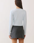 BTTRMMT Blue Sophie Ribbed Button Cardigan back view, fitted ribbed knit cropped cardigan styled with gray mini skort.