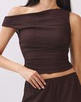 Close view of model wearing the BTTRMMT Daniela Off-Duty Set in brown featuring a fitted ruched back and matching wide-leg pants.