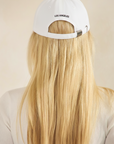 BTTRMMT white Los Angeles cap shown from the back, featuring adjustable strap detail and a clean minimal streetwear look