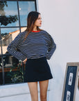 BTTRMMT Ellie Striped Long Sleeve front view worn outdoors in Los Angeles, navy and white stripes with red neckline