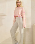 Model wearing BTTRMMT Rae Wide Rib Pant in light beige, styled with a pink striped cropped sweater for a cozy casual look.