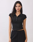 BTTRMMT Black Eliza Fitted Polo Top with a sleek, stretchy silhouette and button-front detail, styled for a clean everyday look.