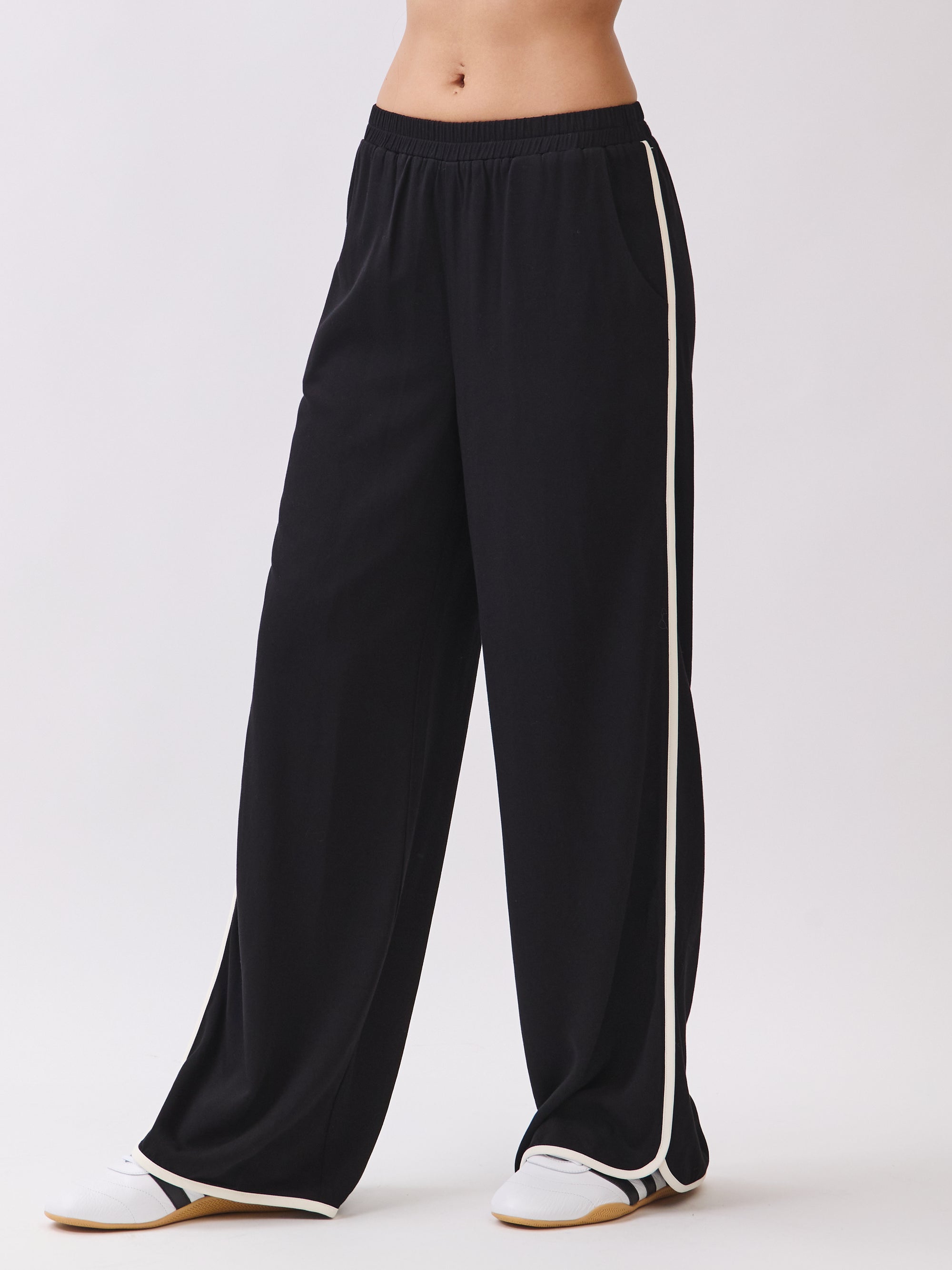 Close-up of the Nova Contrast Trim Pants in black featuring white side piping, elastic waistband, and relaxed fit.