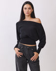 Model wearing BTTRMMT Black Tessa Boatneck Sweater, off-shoulder knit with ribbed waist.
