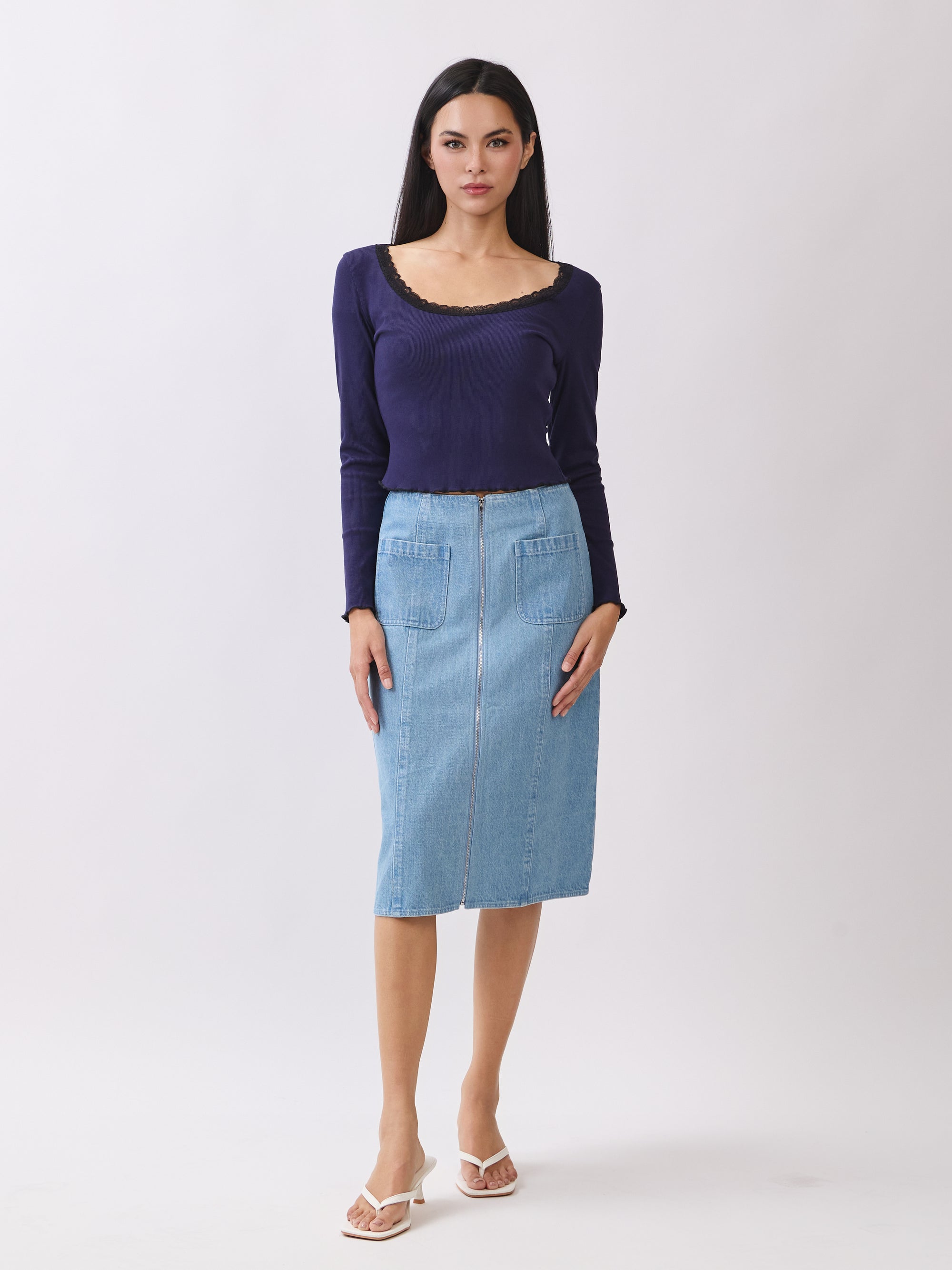 Model wearing BTTRMMT Fiona Denim Midi Skirt with front zipper and patch pockets, styled with a navy long-sleeve top.