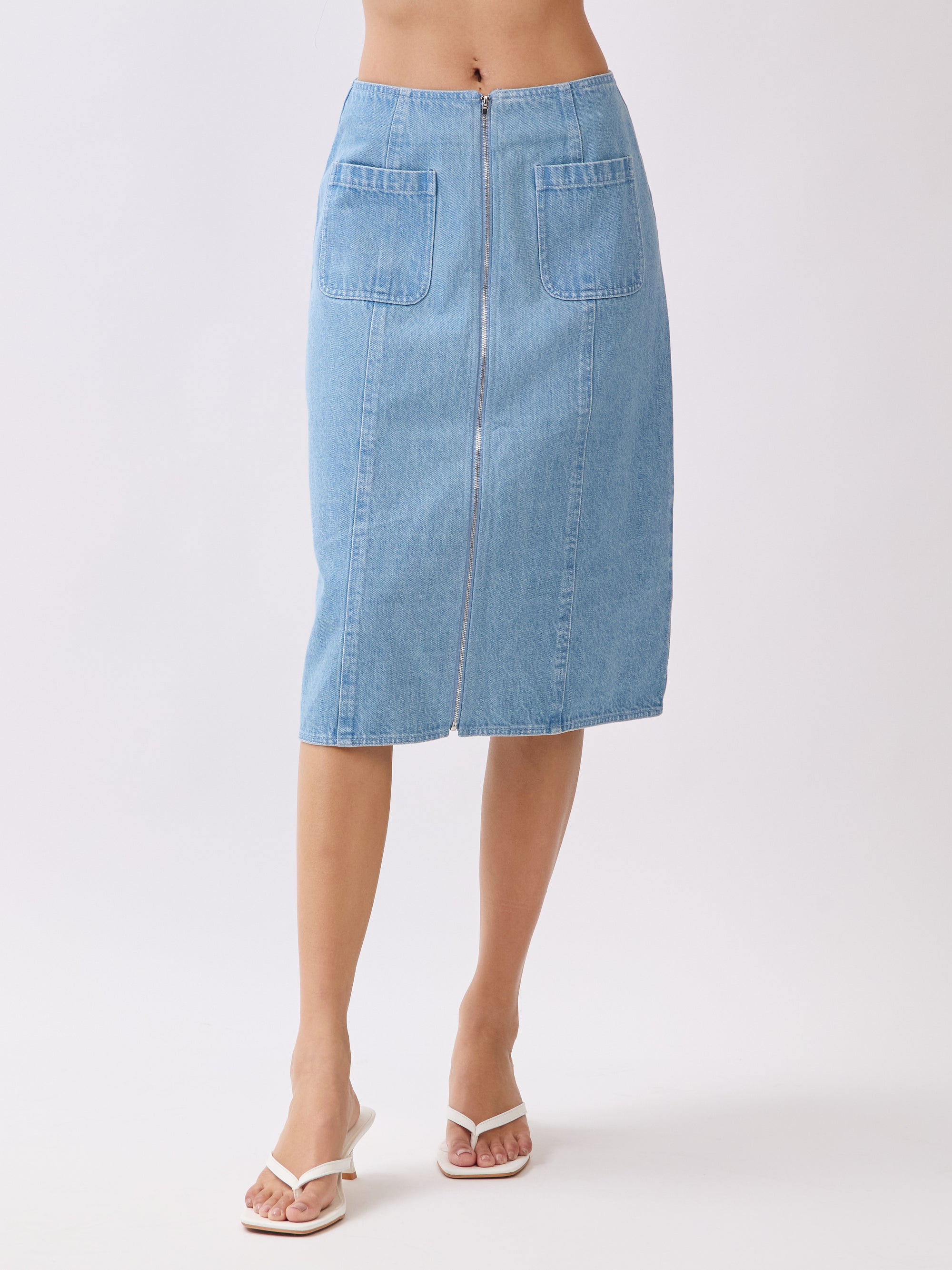 Back view of BTTRMMT Fiona Denim Midi Skirt featuring full-length back zipper and dual patch pockets in light blue denim.