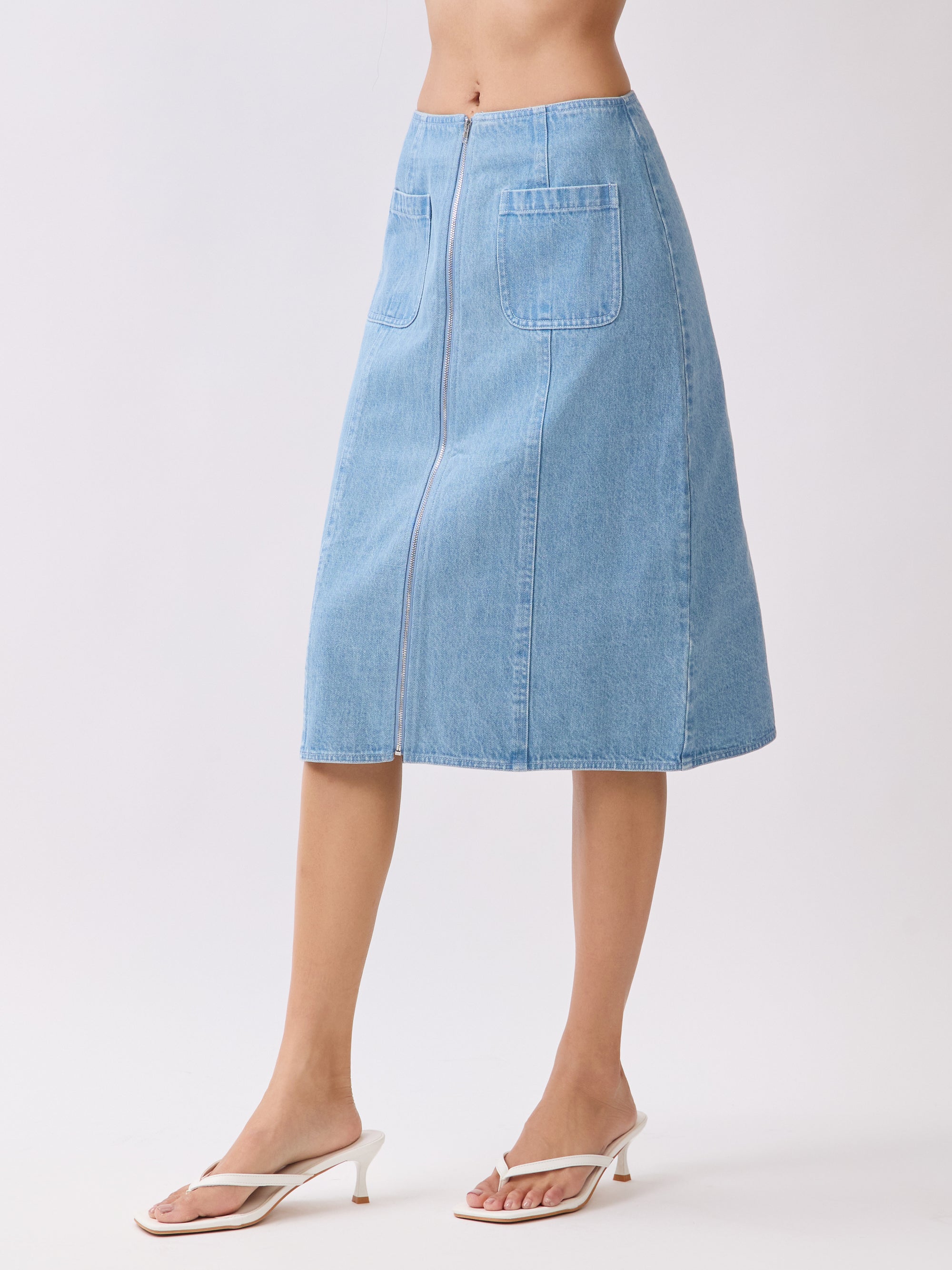 Side view of BTTRMMT Fiona Denim Midi Skirt showing its straight silhouette, clean side paneling, and mid-length denim fit.