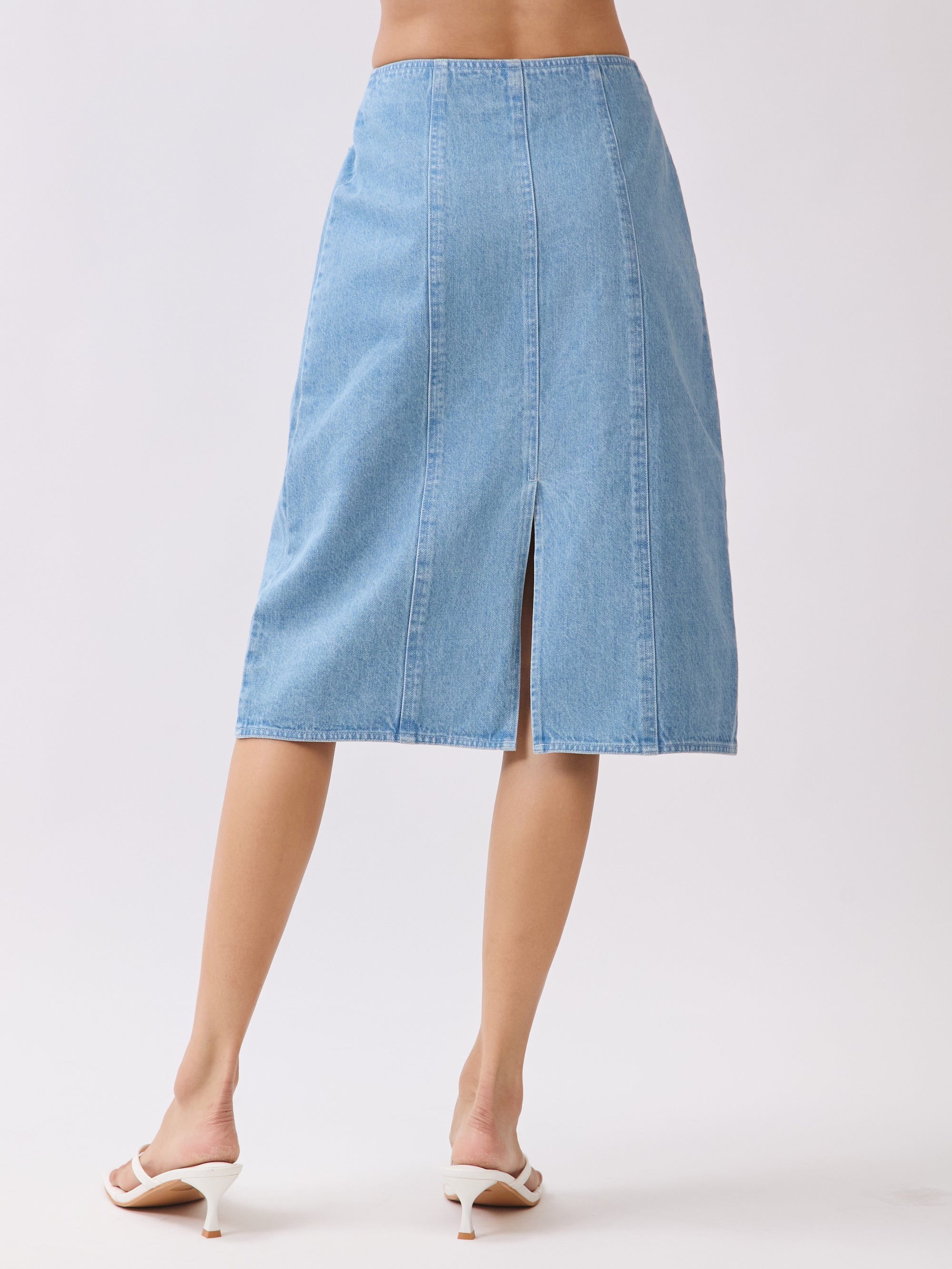 Back view of BTTRMMT Fiona Denim Midi Skirt featuring a full-length back zipper and two patch pockets in light blue denim.