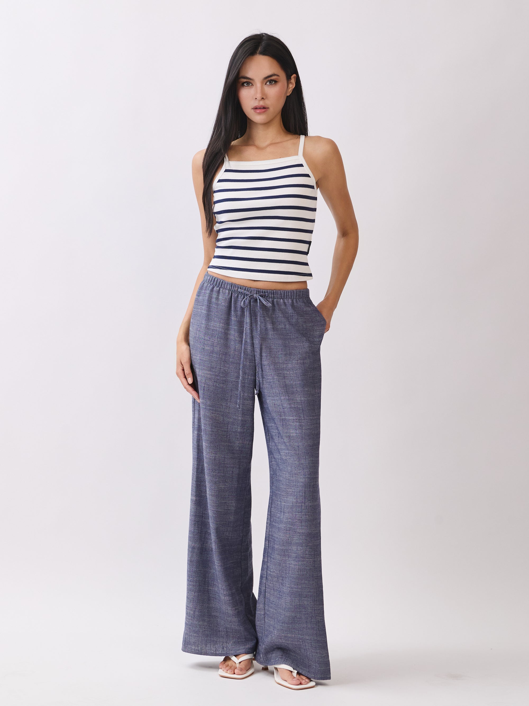 Front view of model wearing BTTRMMT Denim Calia Pants styled with a striped knit tank, featuring a relaxed wide-leg fit and drawstring waist.