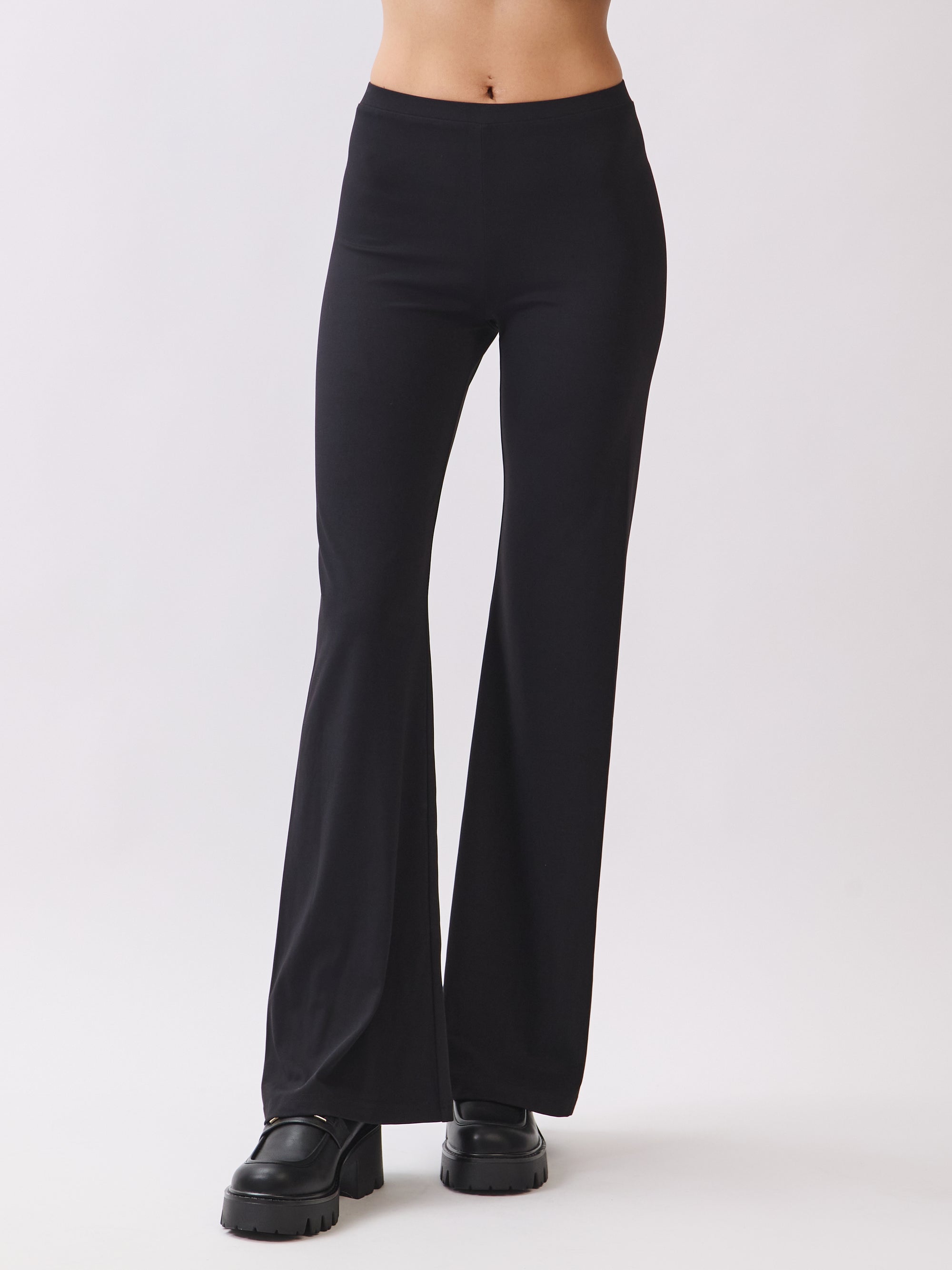 Model wearing BTTRMMT Calista Fit Flare Pants in black featuring a high-stretch fit, smooth waistband, and sleek flared silhouette.