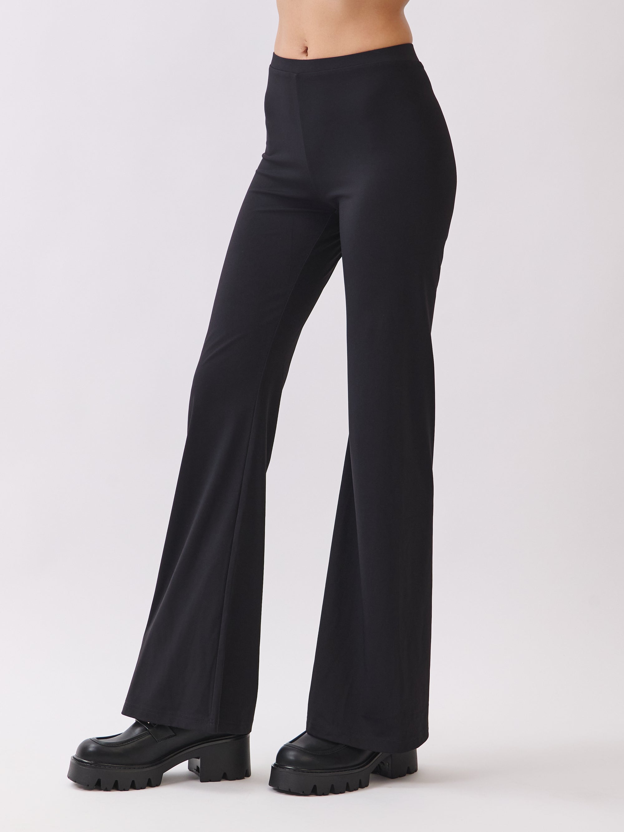 Side view of BTTRMMT Calista Fit Flare Pants in black featuring a smooth waistband, stretchy fit, and sleek flared leg silhouette.