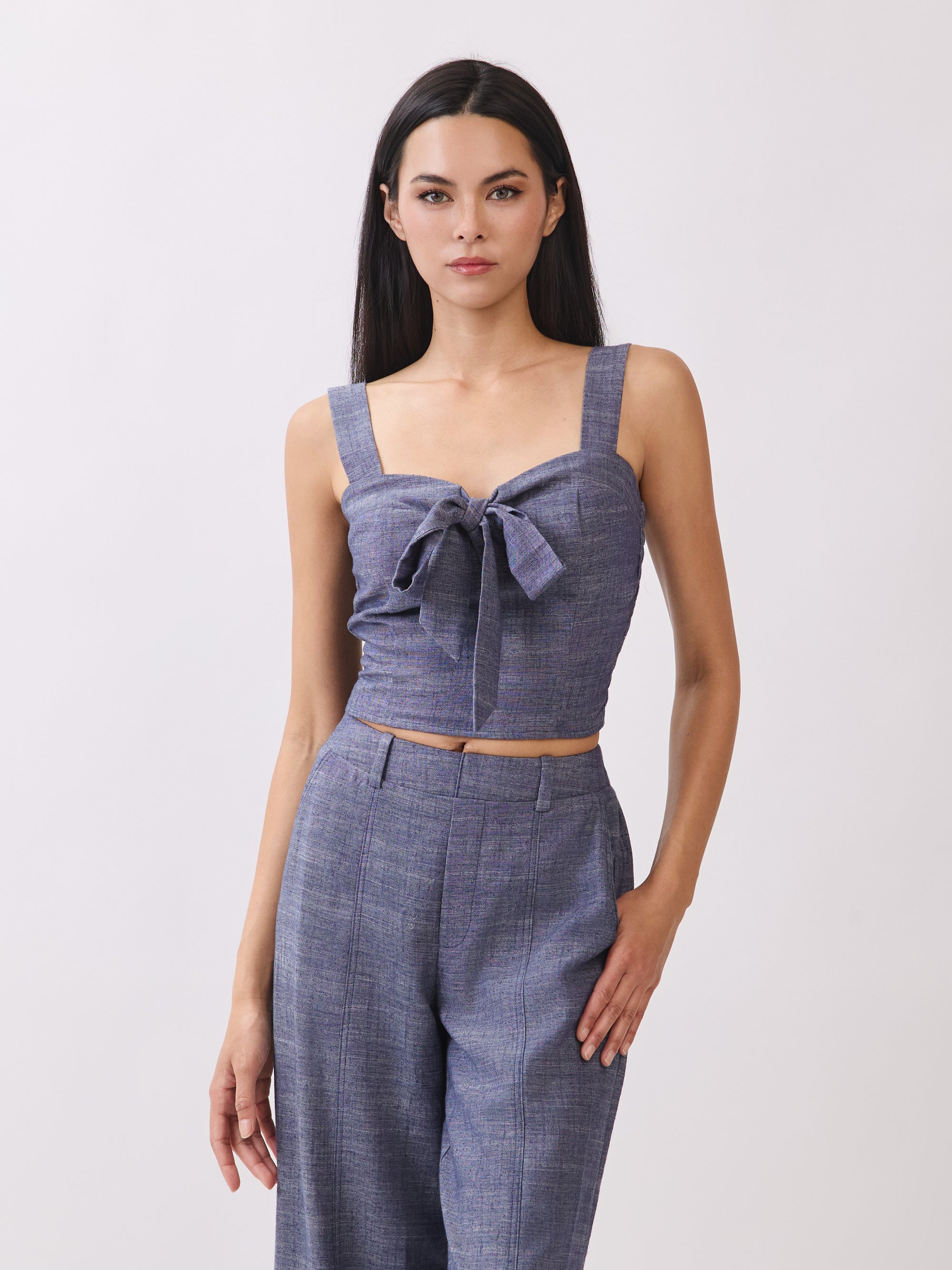 Close-up of BTTRMMT The Delilah Set, blue textured two-piece featuring a tie-front crop top and high-waisted wide-leg pants.
