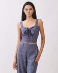 Close-up of BTTRMMT The Delilah Set, blue textured two-piece featuring a tie-front crop top and high-waisted wide-leg pants.