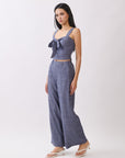 Model wearing BTTRMMT The Delilah Set, blue textured two-piece with tie-front crop top and matching wide-leg pants.