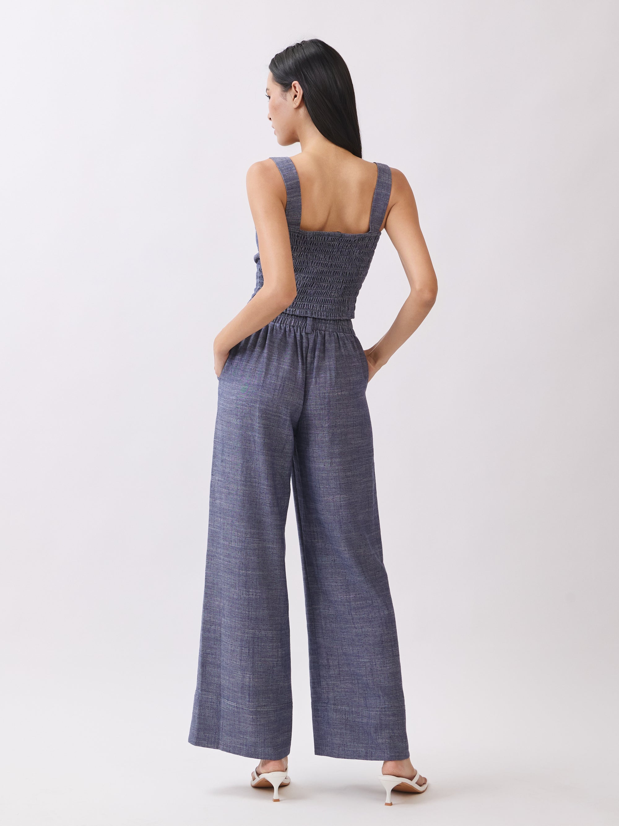 Back view of BTTRMMT The Delilah Set, blue textured two-piece showing square-back crop top and wide-leg pants.