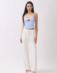 Model wearing BTTRMMT Ivory Yuna Soft Wide Leg Pants with elastic drawstring waist and flowy fit, paired with a light blue tank.
