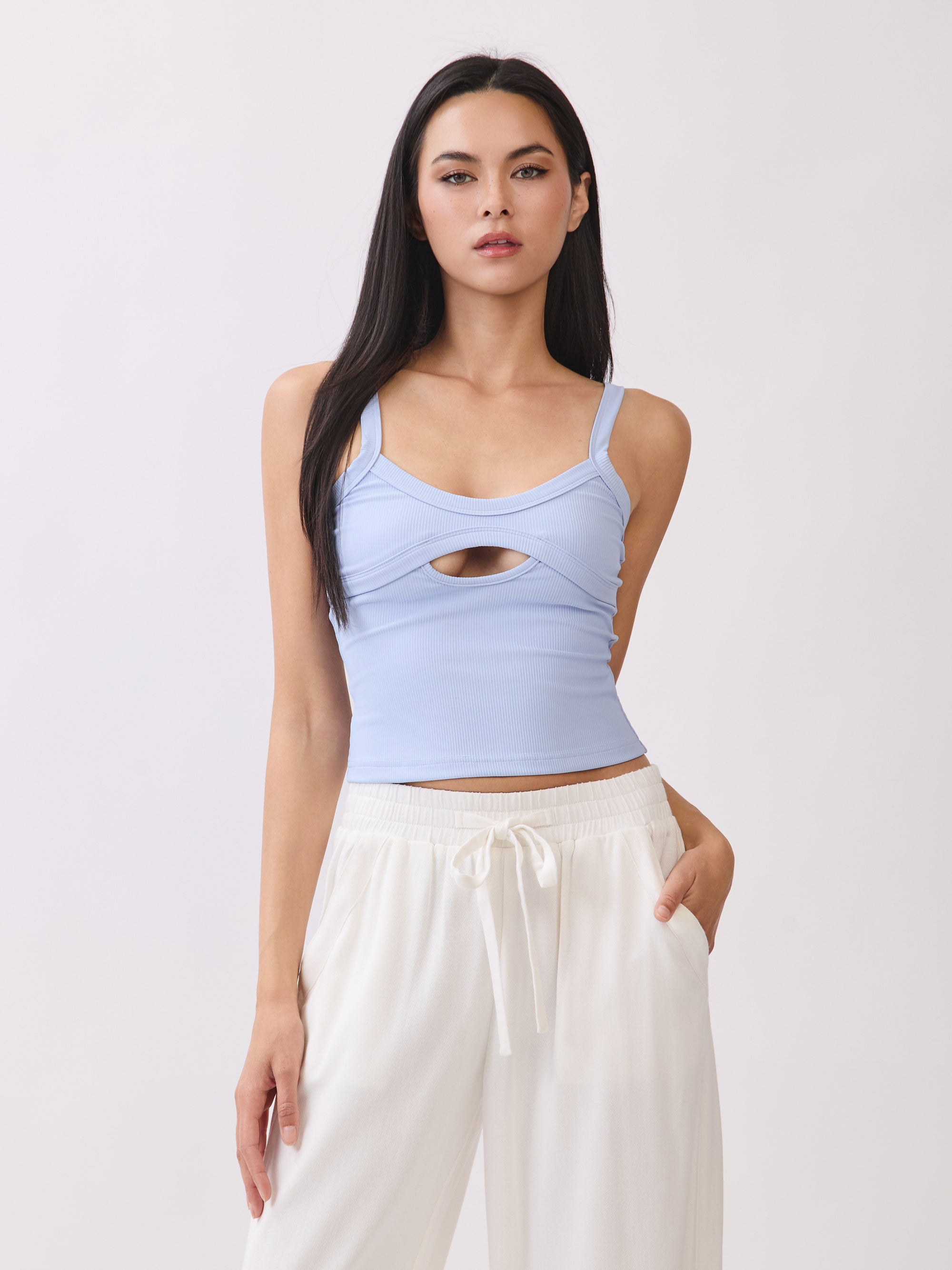 Model wearing BTTRMMT light blue cutout tank top with scoop neckline, paired with white drawstring pants.