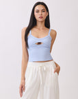 Model wearing BTTRMMT light blue cutout tank top with scoop neckline, paired with white drawstring pants.