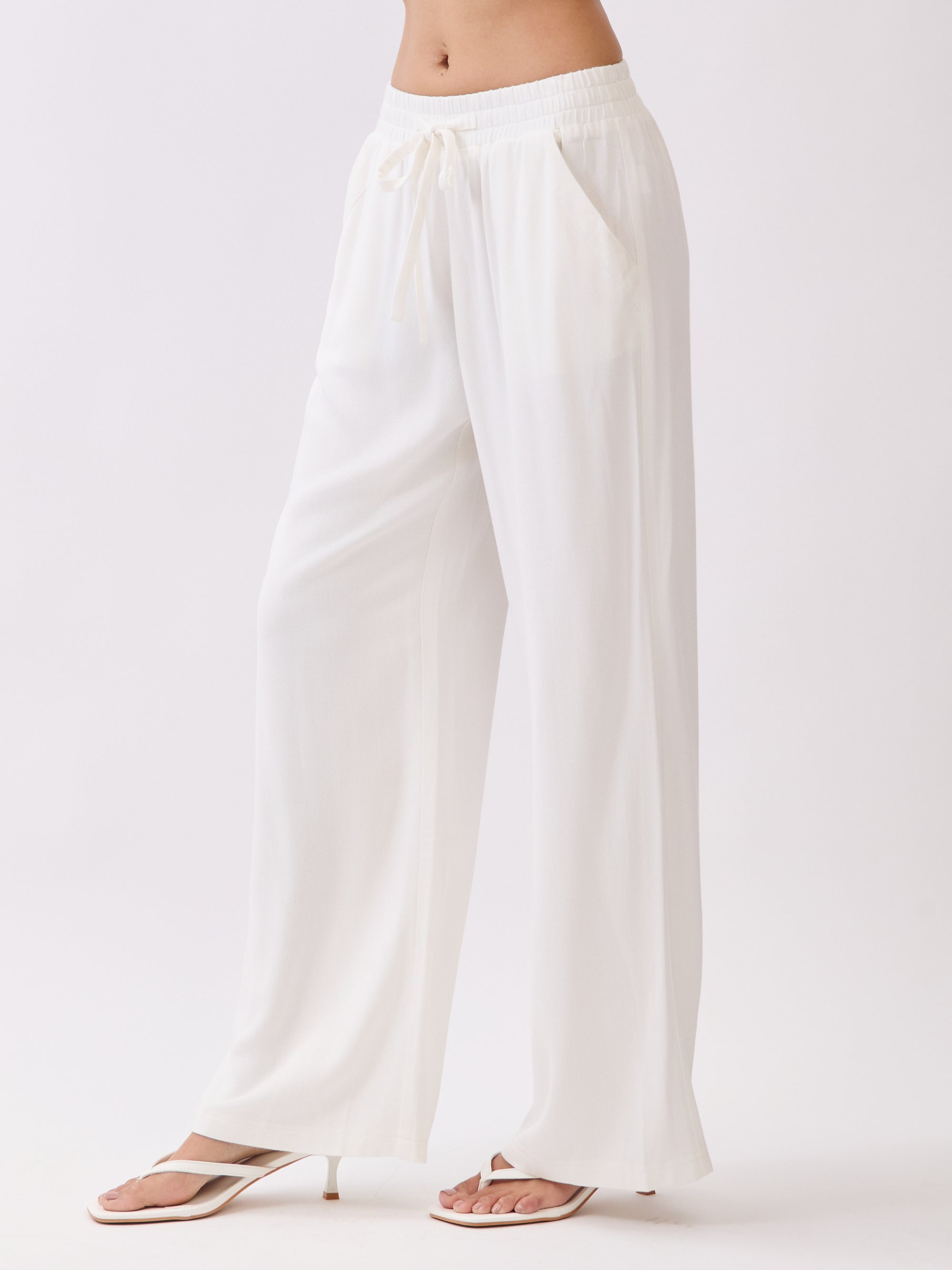 Side view of BTTRMMT Ivory Yuna Soft Wide Leg Pants featuring a flowy drape, elastic waistband, and relaxed lightweight fit.
