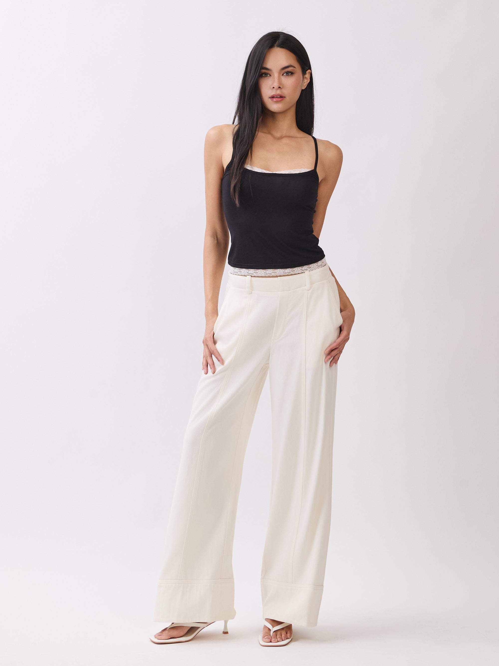 Model wearing BTTRMMT Ivory Sophia Pants with a high waist, pleated front, and wide-leg silhouette for an elegant, tailored look.