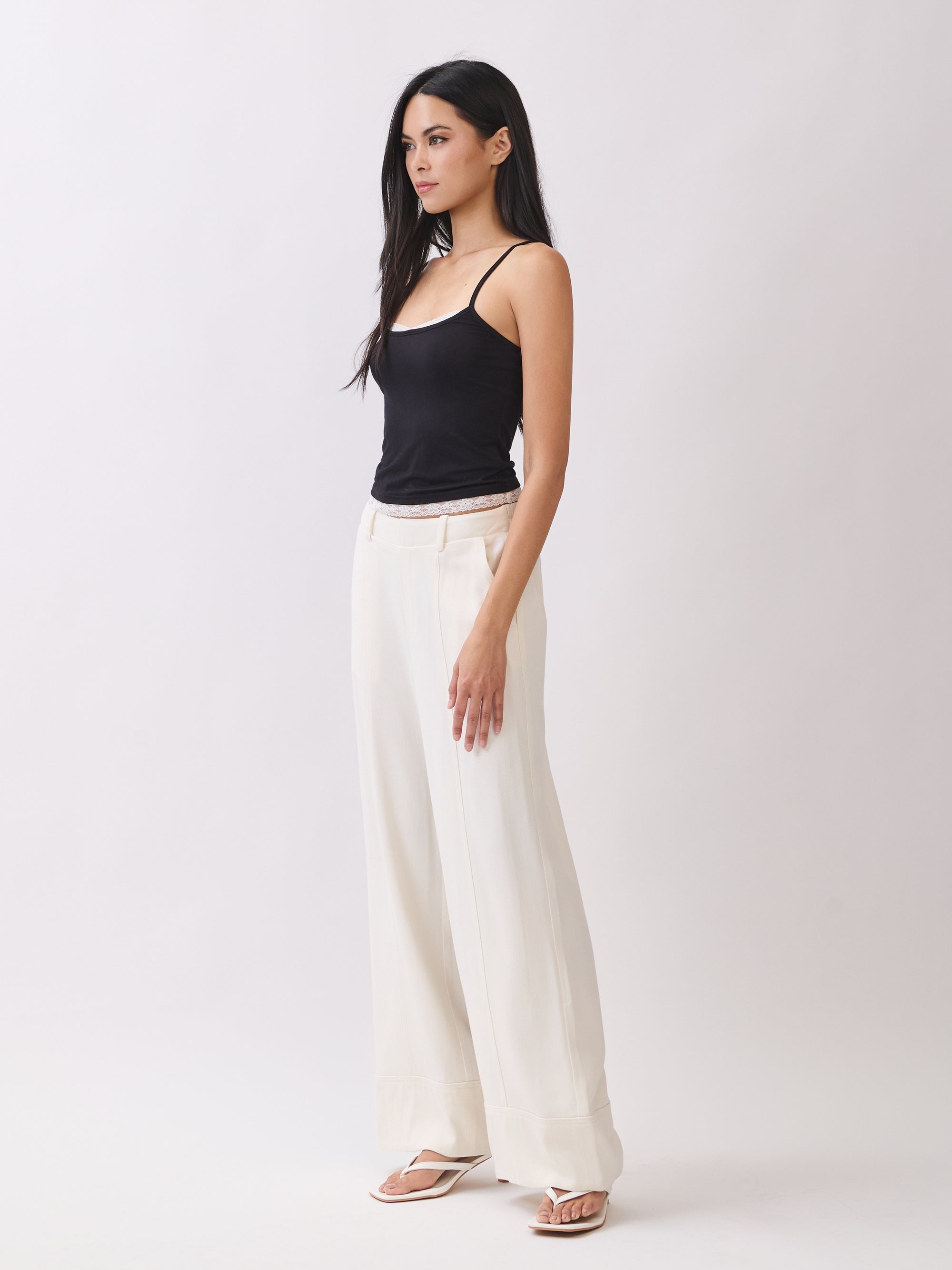Model wearing BTTRMMT Ivory Sophia Pants with a high waist, pleated front, and wide-leg silhouette for an elegant, tailored look.