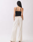 Model wearing BTTRMMT Ivory Sophia Pants with a high waist, pleated front, and wide-leg silhouette for an elegant, tailored look.