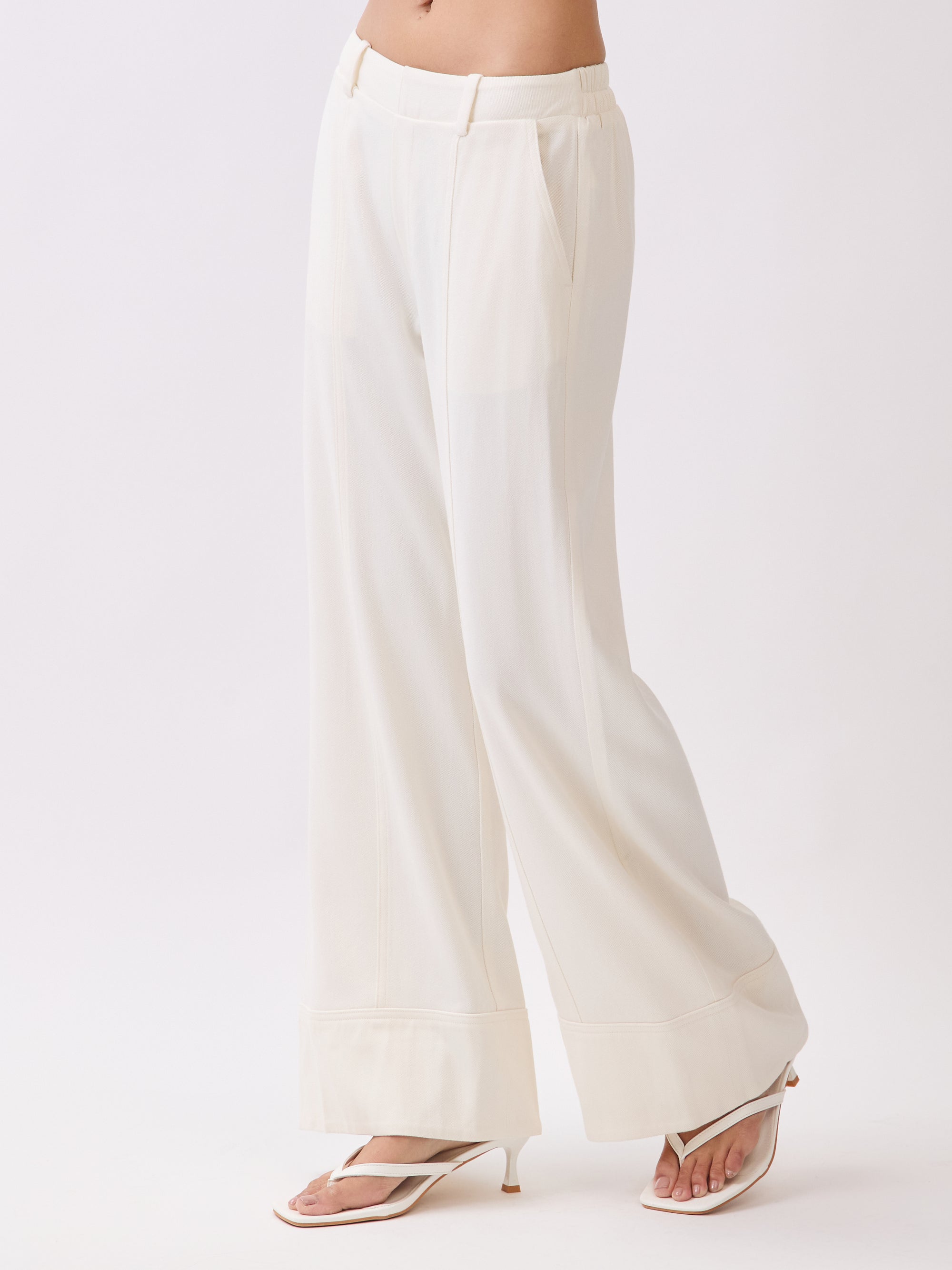 Side view of BTTRMMT Ivory Sophia Pants featuring a high-waist tailored fit, front seam detail, and wide-leg silhouette
