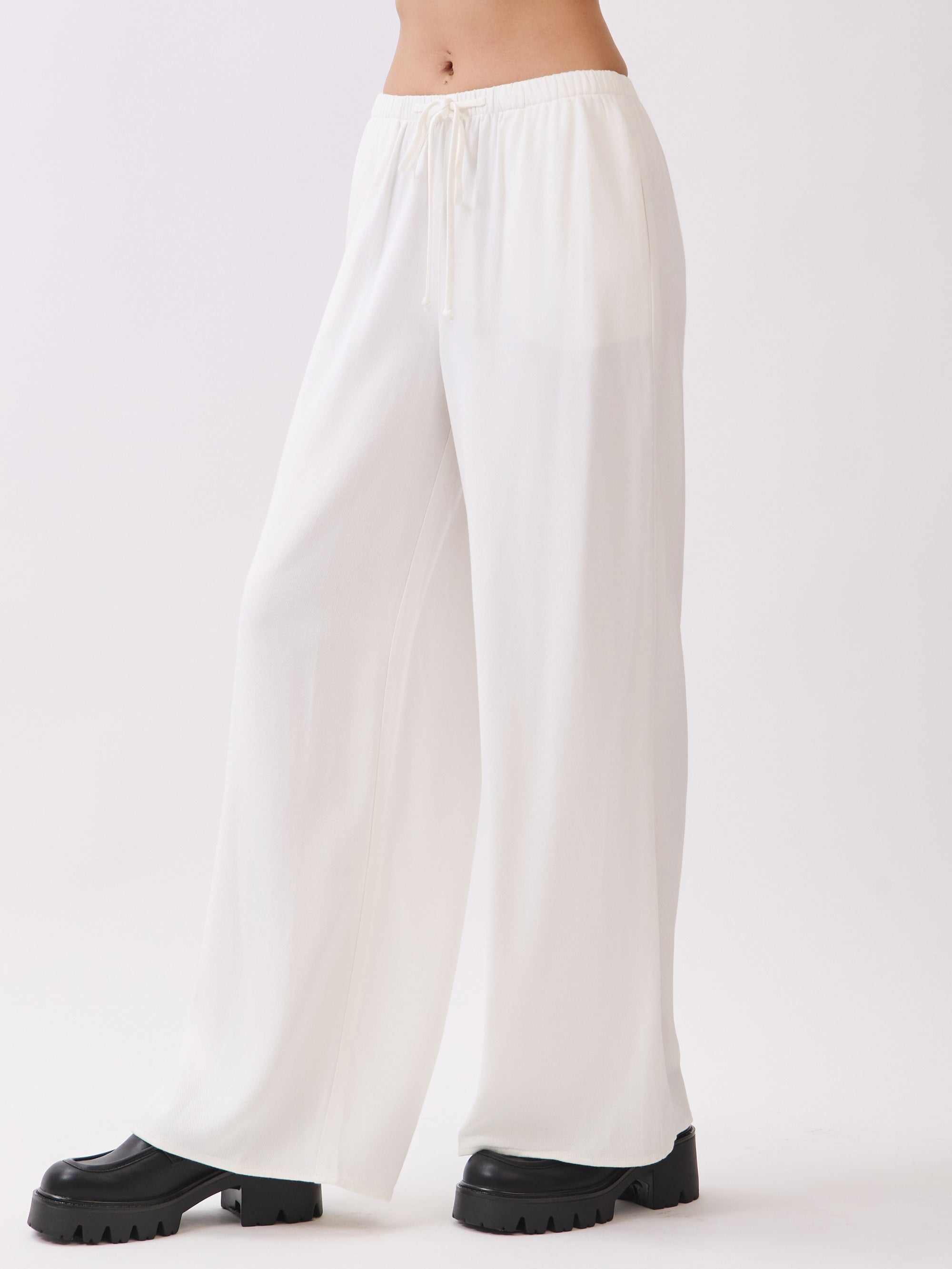 Side view of BTTRMMT Ivory Calia Pants featuring a relaxed wide-leg fit and soft draped silhouette.