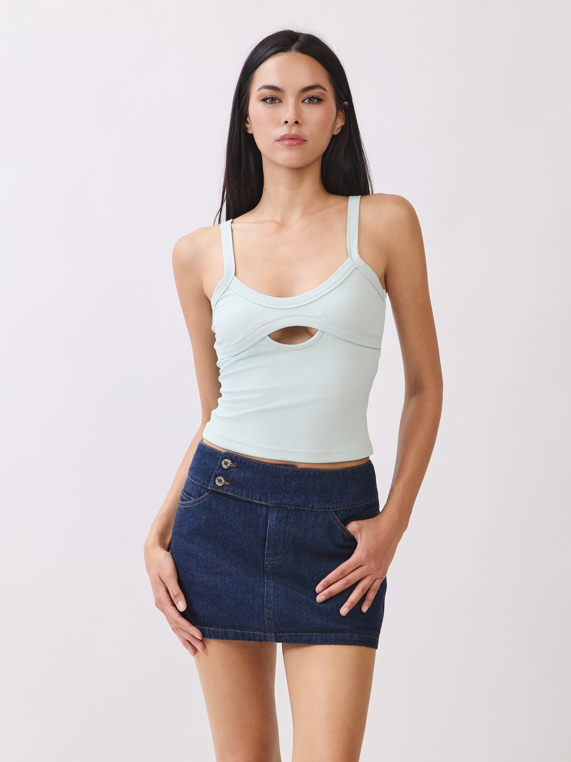 Model wearing BTTRMMT mint cutout tank top with scoop neckline, paired with dark denim mini skirt.
