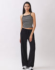 Model wearing BTTRMMT Black Yuna Soft Wide Leg Pants with drawstring waist and relaxed fit, paired with striped knit tank and sneakers.