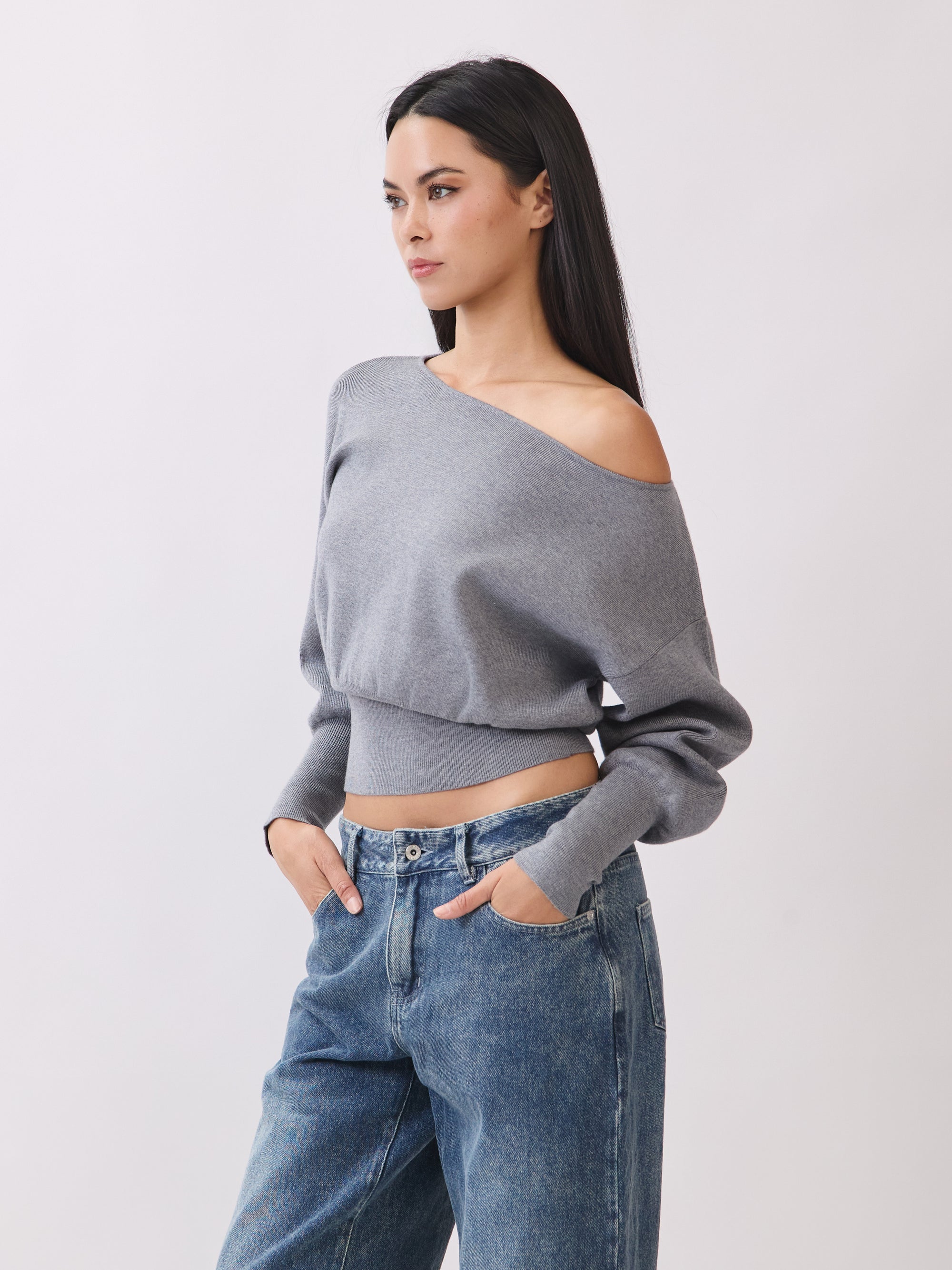 Side view of Model wearing BTTRMMT Gray Tessa Boatneck Sweater, ribbed off-shoulder knit with long sleeves.