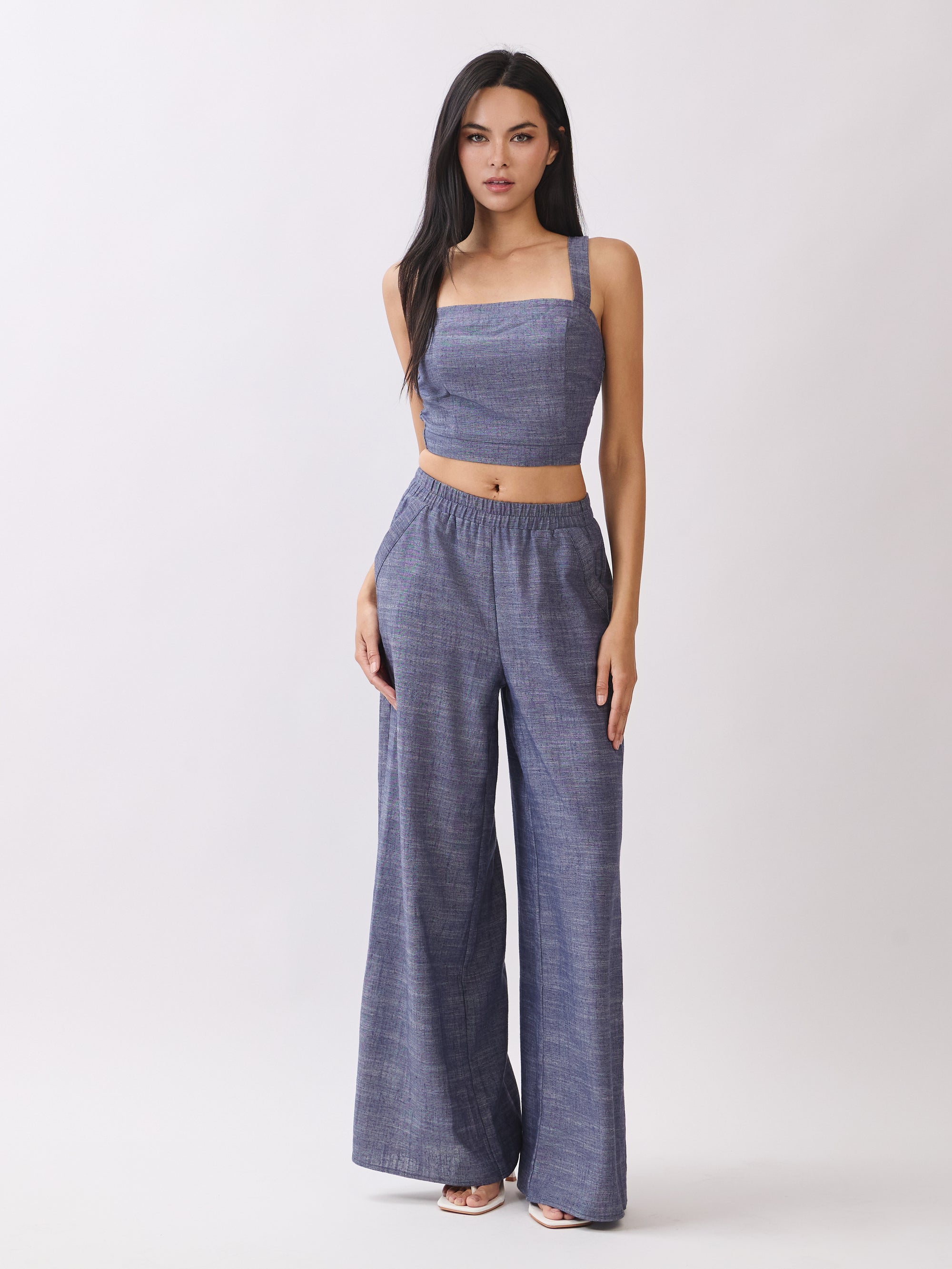 Model wearing BTTRMMT Denim Olivyn Set in blue with a square-neck cropped top and matching high-waist wide-leg pants.